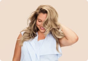 Woman touching her voluminous highlighted blonde hair