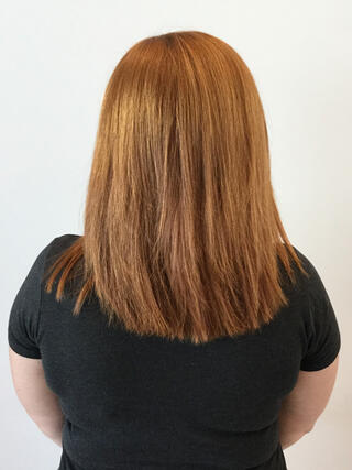 Before Photo: rear view of woman with medium-length uneven light brown hair with grown out roots before colour.