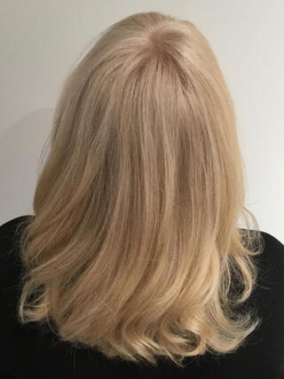 After Photo: rear view of woman with medium-length even blonde hair after colour.