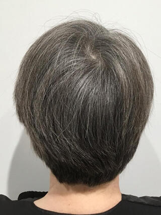 Before Photo: rear view of woman with short black hair with a lot of grey before colour.