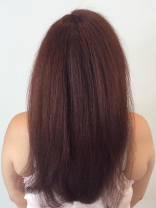 After photo: rear view of woman with long healthy red hair after colour.